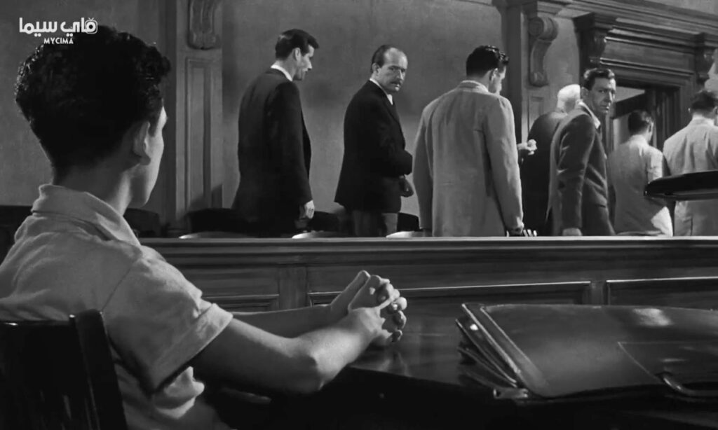 مراجعة فلم 12 Angry Men (هيئة المحلفين) 5 لحظة ذهاب هيئة المحلفين إلى غرفة المحلفين (12 Angry Men)، بعد تعليمات القاضي، وجلوس الطفل في انتظار الحكم.